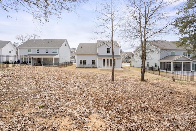 rear view of property with a sunroom, a patio, a fenced backyard, and a residential view