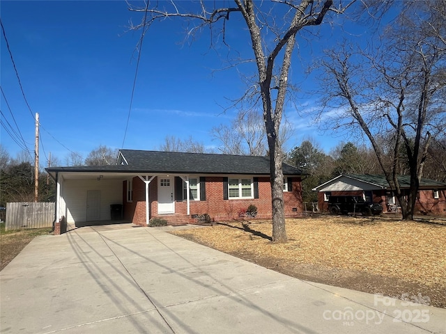 ranch-style home with concrete driveway, brick siding, fence, and an attached carport