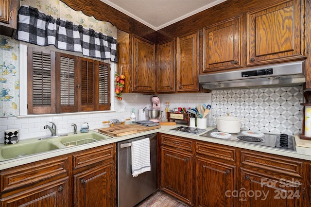 kitchen featuring appliances with stainless steel finishes, backsplash, a textured ceiling, crown molding, and sink