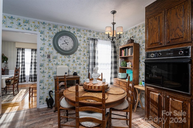 dining room with a textured ceiling, dark hardwood / wood-style flooring, crown molding, and a notable chandelier