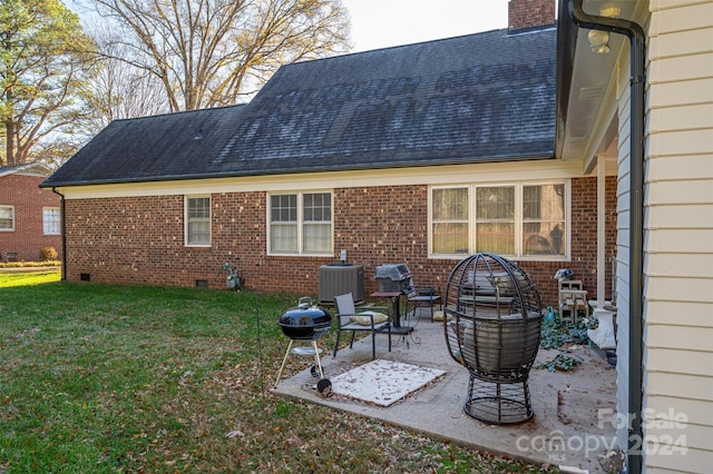 back of house featuring a lawn, cooling unit, and a patio area