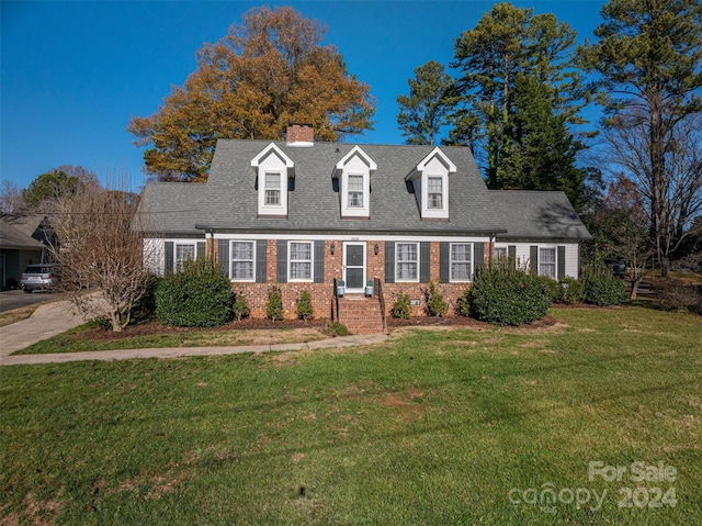 cape cod-style house featuring a front yard