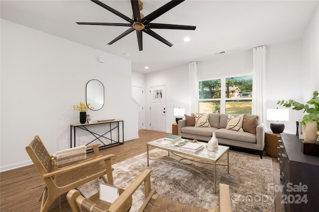 living room featuring wood-type flooring and ceiling fan