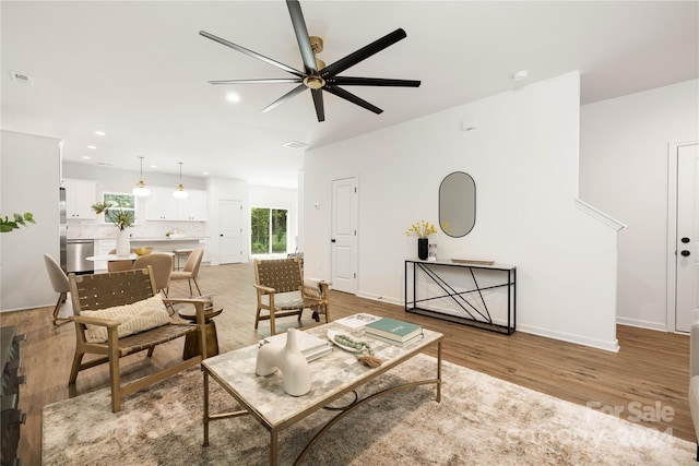 living room with ceiling fan and light hardwood / wood-style floors