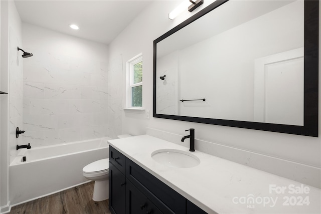 full bathroom with vanity, toilet, tiled shower / bath, and hardwood / wood-style flooring