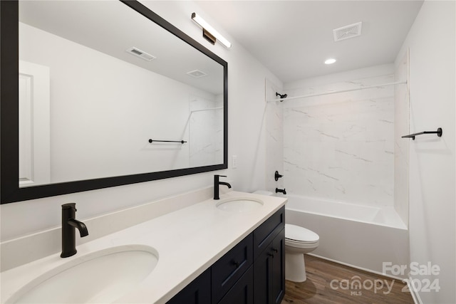 full bathroom with hardwood / wood-style floors, tiled shower / bath combo, toilet, and vanity