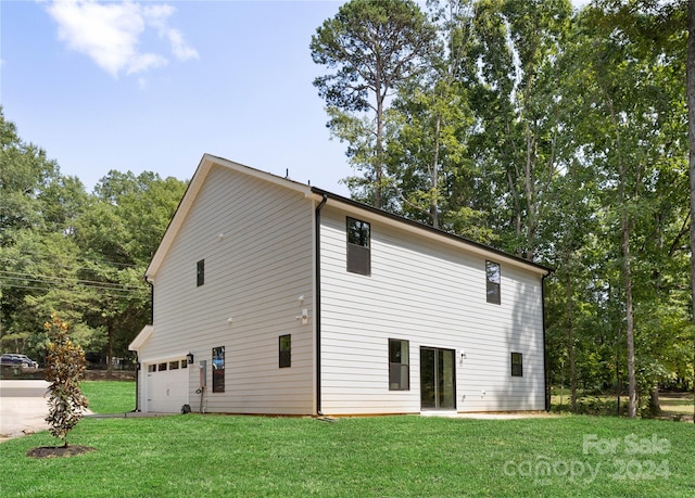 rear view of house with a lawn and a garage