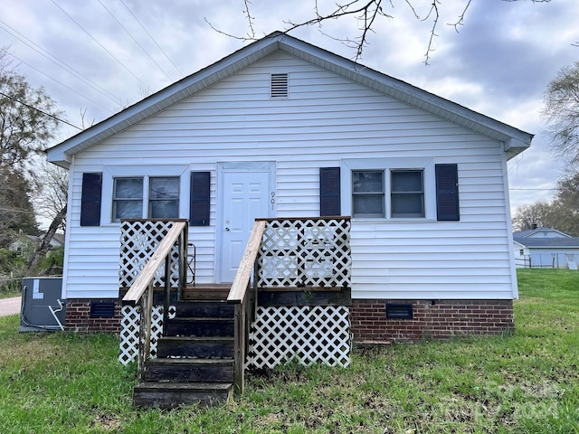 back of house featuring central AC unit and a lawn