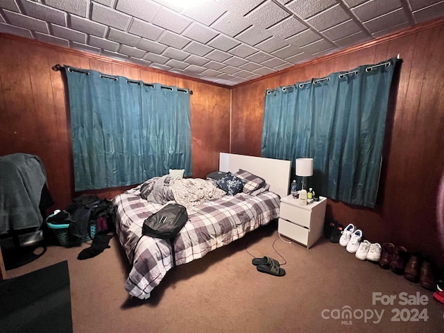 bedroom featuring carpet floors and wood walls