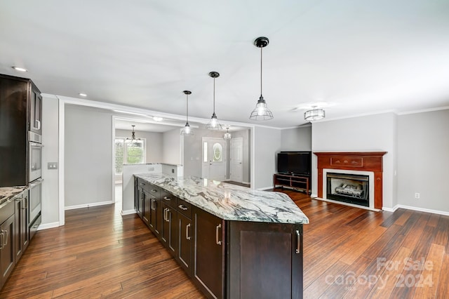 kitchen featuring light stone counters, dark hardwood / wood-style floors, and decorative light fixtures