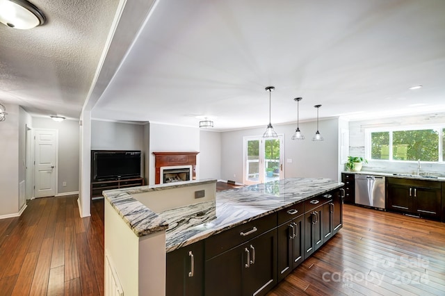 kitchen featuring dishwasher, a kitchen island, dark wood-type flooring, and sink