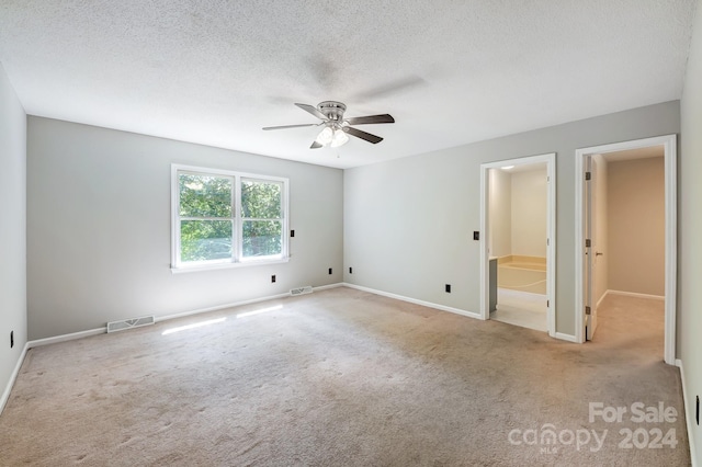 carpeted spare room with a textured ceiling and ceiling fan