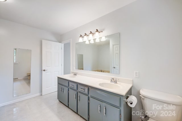 bathroom featuring tile patterned floors, vanity, and toilet