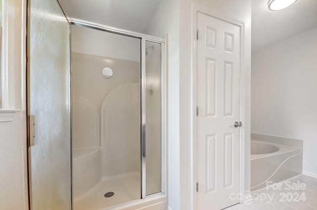 bathroom featuring tile patterned flooring and separate shower and tub