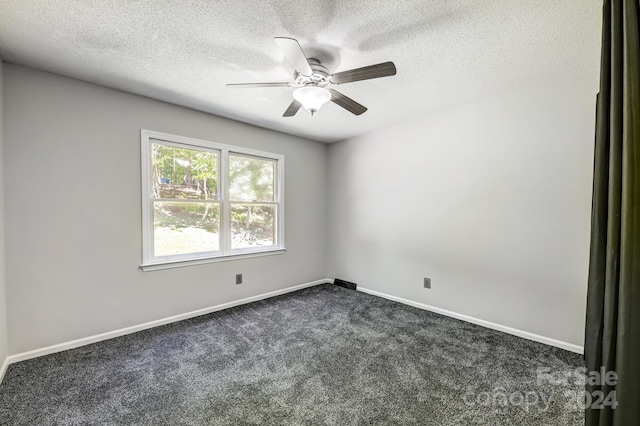 carpeted empty room featuring ceiling fan and a textured ceiling