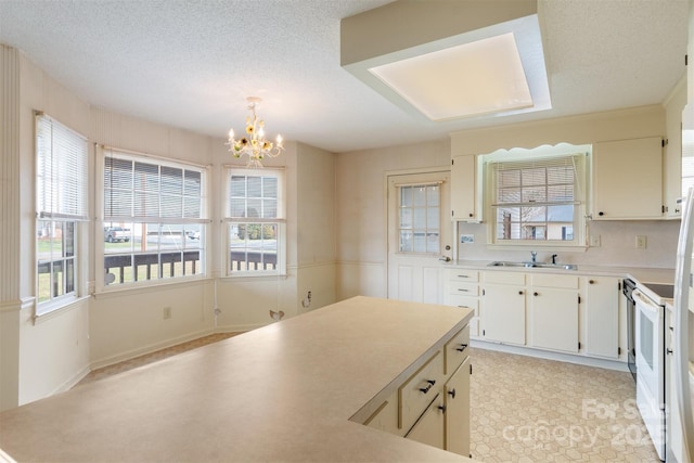 kitchen with decorative light fixtures, sink, a wealth of natural light, and a chandelier