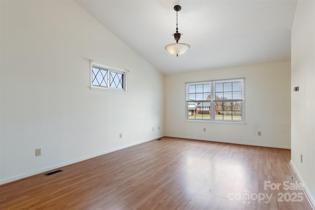 empty room featuring high vaulted ceiling and light wood-type flooring