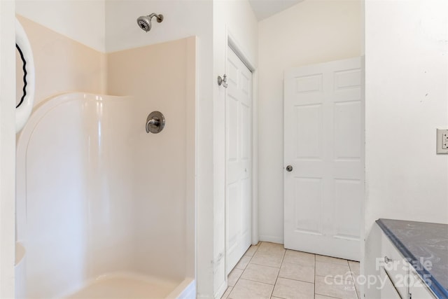 bathroom featuring vanity, a shower, and tile patterned floors