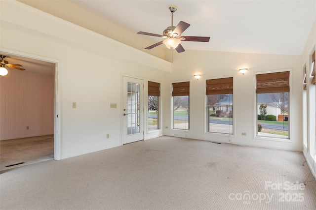 spare room featuring light carpet, ceiling fan, and vaulted ceiling