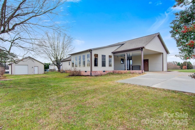 ranch-style house with a front lawn, a garage, an outbuilding, and a carport