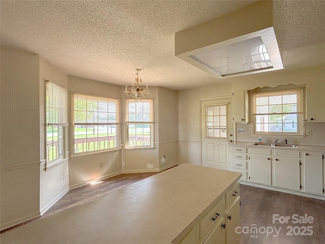 9566 Wilson Rd, Hildebran, NC 28637 - kitchen with a textured ceiling, dark wood finished floors, a chandelier, a sink, and light countertops