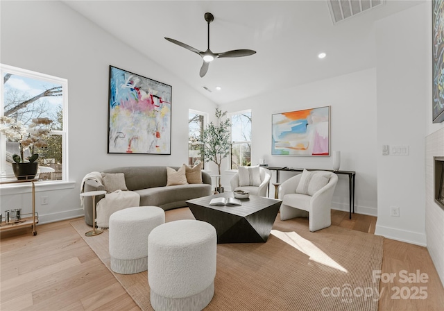 living room with ceiling fan, light hardwood / wood-style flooring, and lofted ceiling