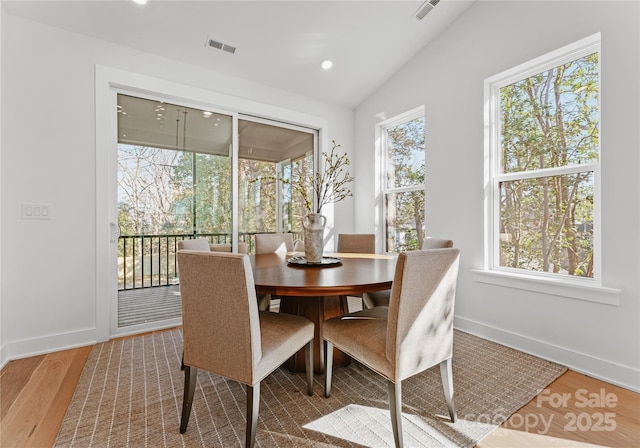 dining room featuring hardwood / wood-style flooring and lofted ceiling