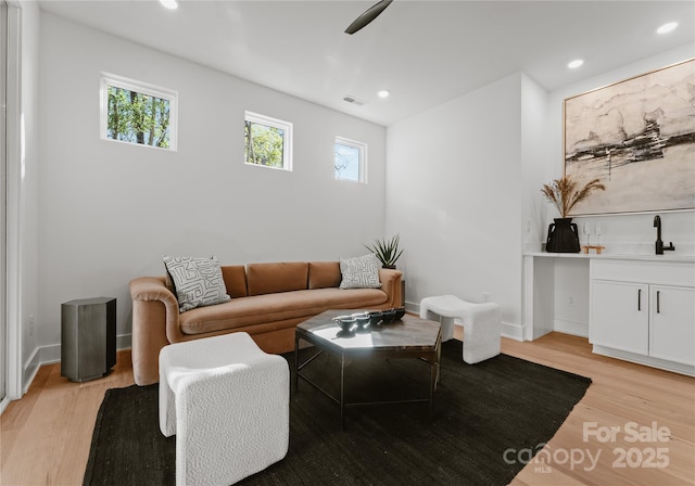 living room with light hardwood / wood-style flooring and sink