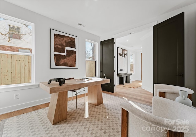 home office featuring light hardwood / wood-style floors and an inviting chandelier