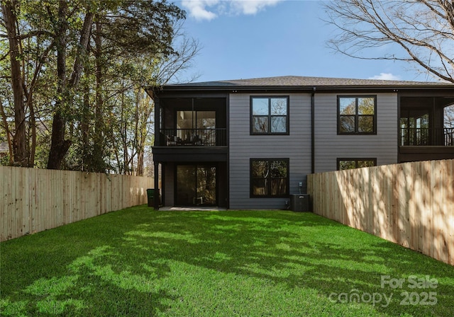 rear view of house featuring a sunroom and a yard