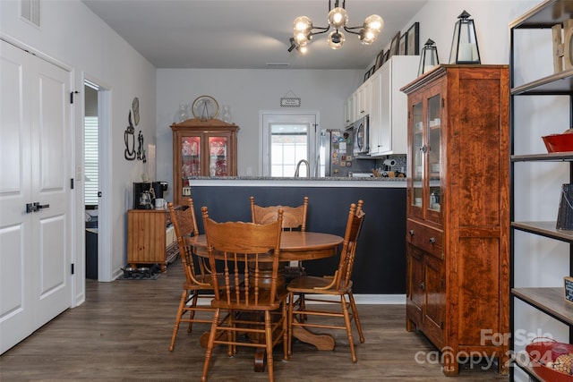 dining area featuring dark hardwood / wood-style flooring and an inviting chandelier