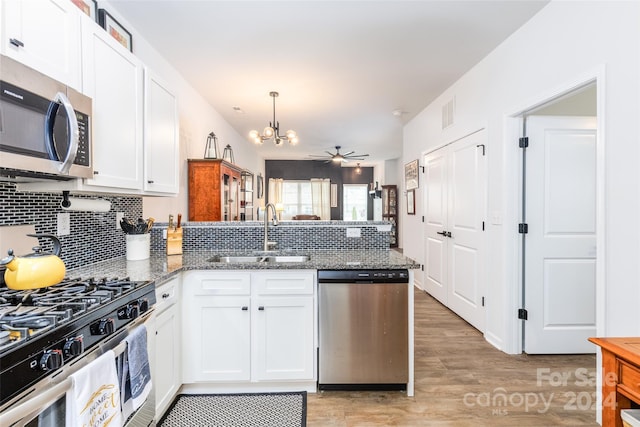 kitchen featuring white cabinets, light wood-type flooring, stainless steel appliances, and sink