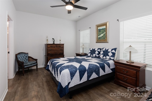 bedroom with ceiling fan, dark hardwood / wood-style floors, and multiple windows