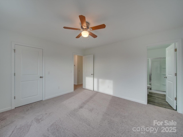 unfurnished bedroom with ceiling fan, ensuite bathroom, and carpet floors