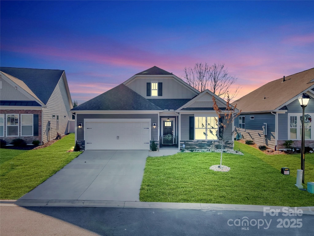 view of front of property featuring a garage and a lawn