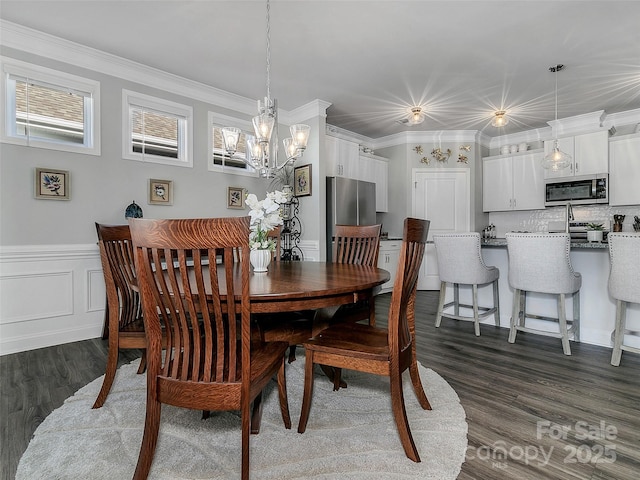 dining space with ornamental molding, dark wood-type flooring, and a chandelier