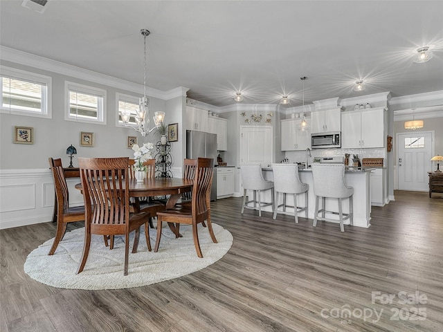 dining space featuring crown molding, dark hardwood / wood-style floors, and an inviting chandelier