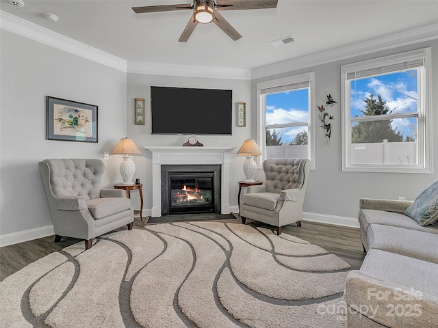 living room featuring ceiling fan, ornamental molding, and dark hardwood / wood-style floors