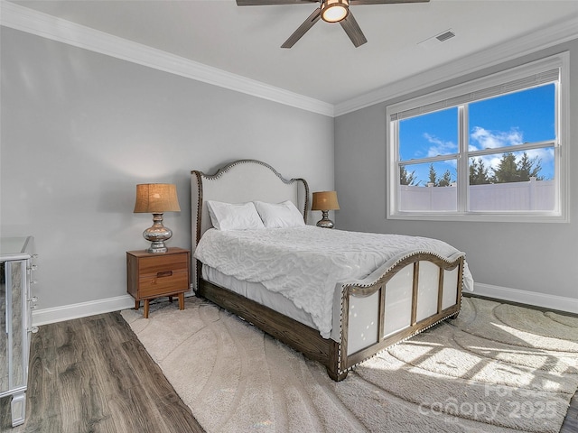 bedroom featuring crown molding, hardwood / wood-style flooring, and ceiling fan