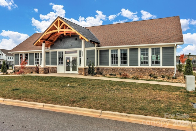 craftsman-style home with a front lawn and french doors