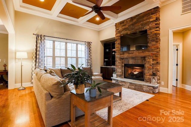 living room with beamed ceiling, a fireplace, crown molding, and coffered ceiling