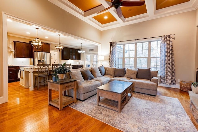 living room with ornamental molding, coffered ceiling, ceiling fan, beam ceiling, and light hardwood / wood-style flooring