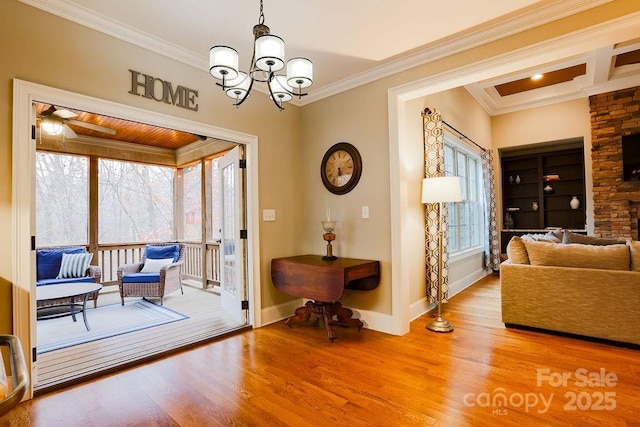 interior space with ceiling fan with notable chandelier, hardwood / wood-style flooring, and ornamental molding