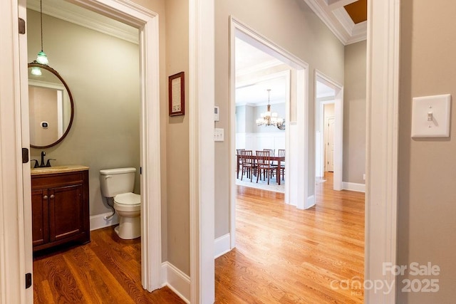 bathroom with vanity, crown molding, hardwood / wood-style flooring, toilet, and a chandelier