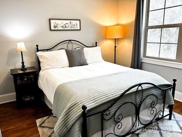 bedroom with dark hardwood / wood-style flooring