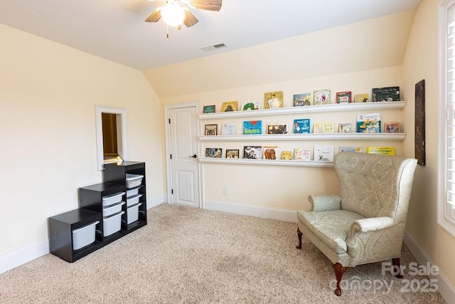 living area featuring carpet flooring, vaulted ceiling, and ceiling fan