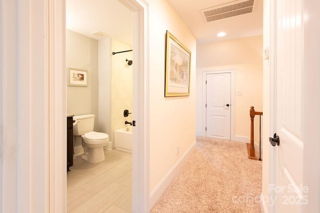 hallway featuring light colored carpet