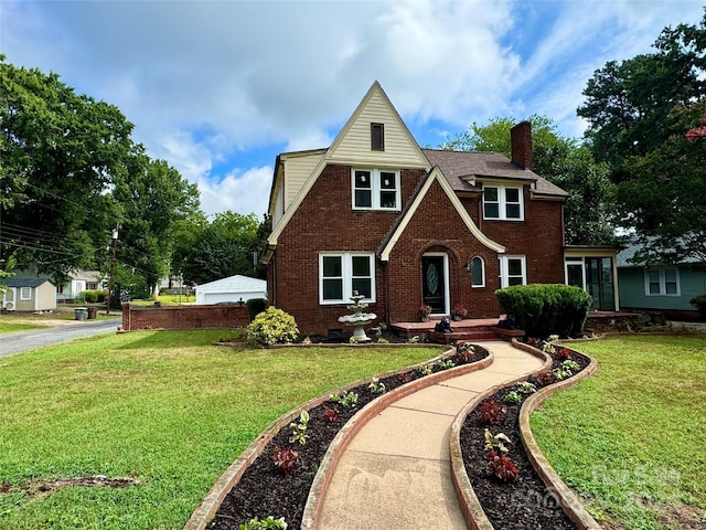 tudor-style house featuring a front lawn