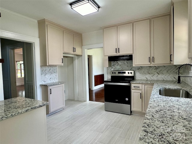 kitchen featuring light stone countertops, sink, backsplash, light hardwood / wood-style floors, and stainless steel range with electric cooktop