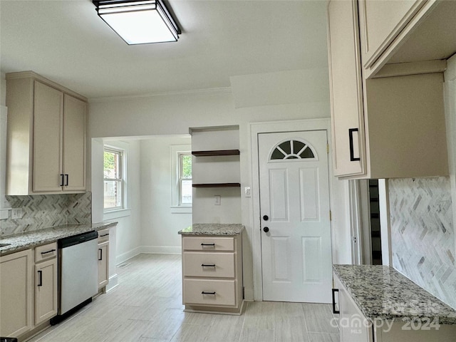 kitchen featuring light stone countertops, cream cabinets, backsplash, and stainless steel dishwasher